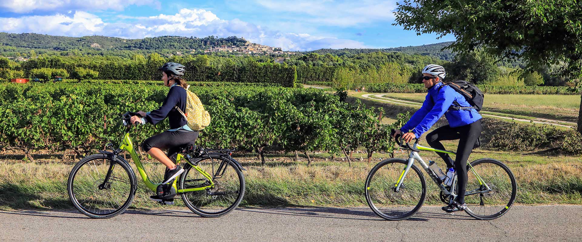 Couple à vélo route vigne village provençal