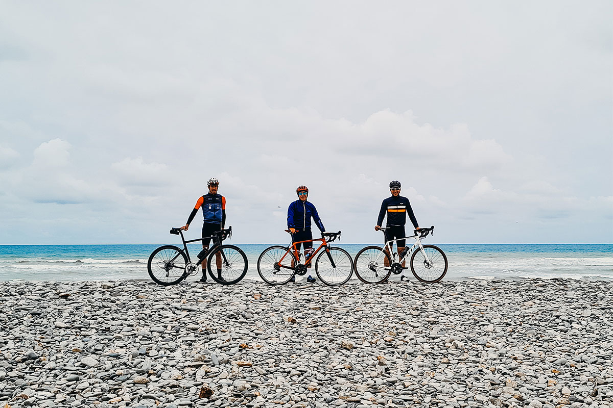 3 homme sur une plage de galets