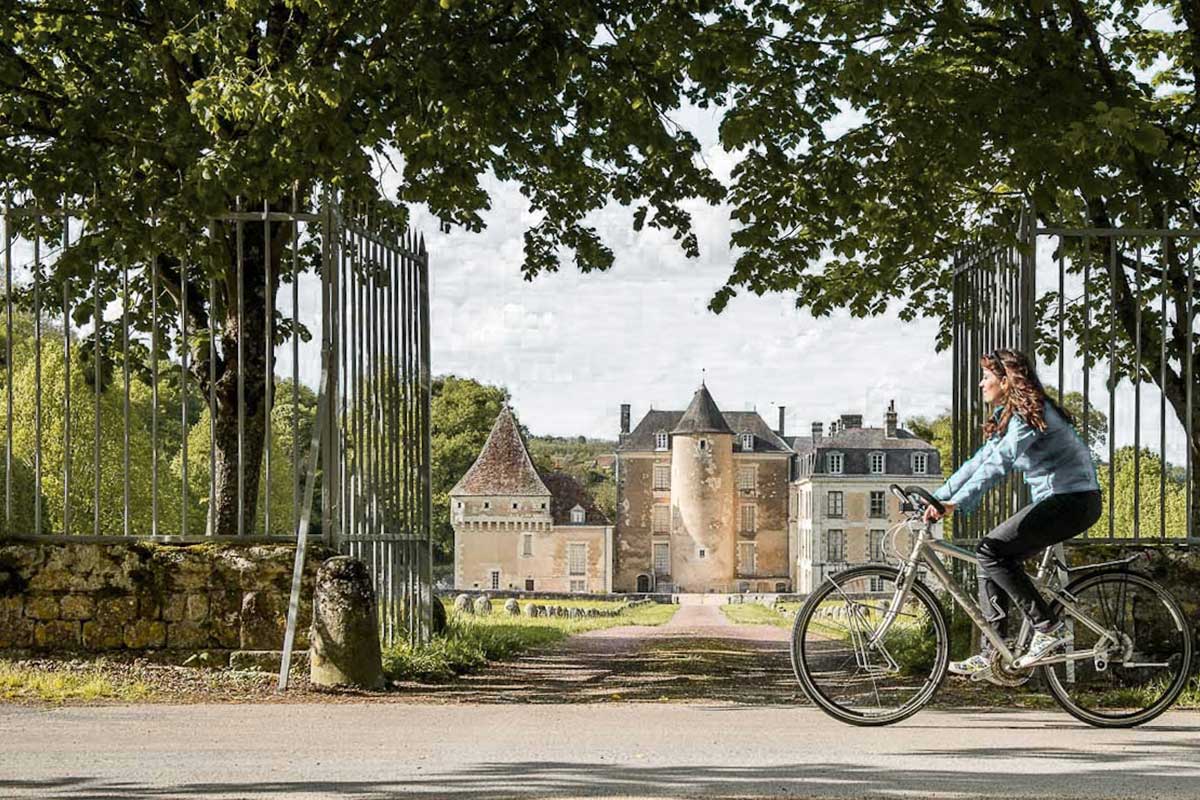 Femme à vélo devant un château