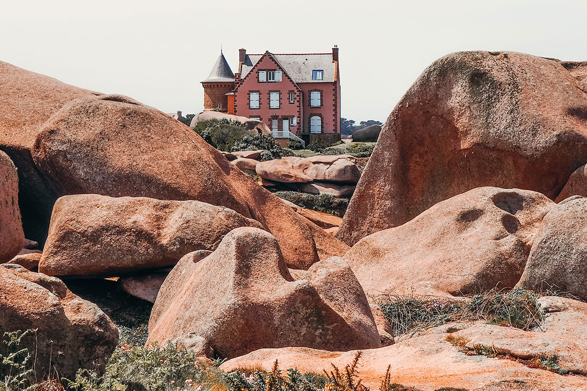 Maison rose entourée de granit