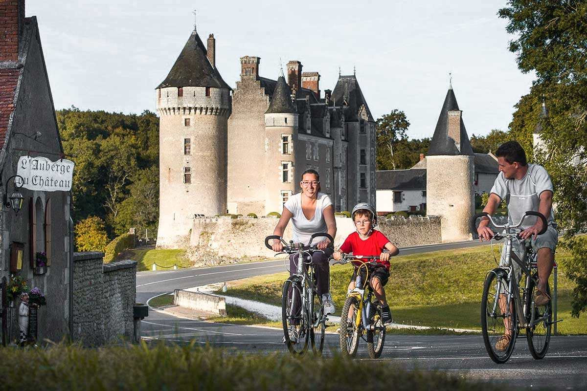 Famille à vélo devant un château