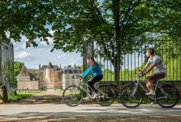 Un couple se baladant à vélo devant un château