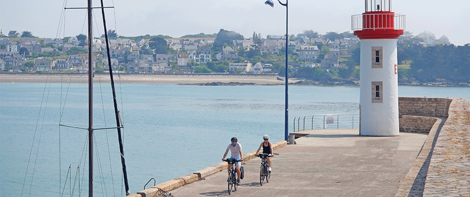 Deux cyclistes sur le route d'un phare