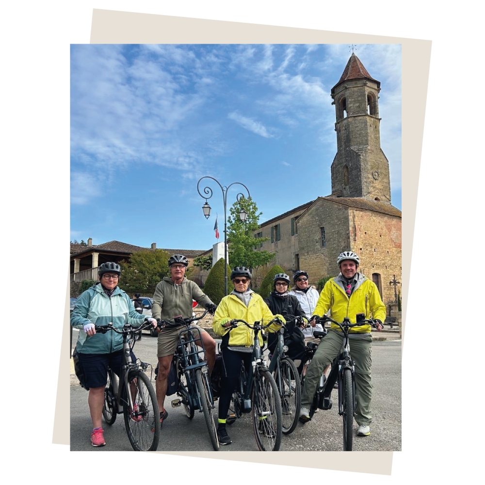 Un groupe de cycliste pose dans une jolie ville de Dordogne