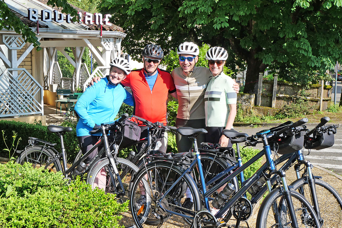 4 cyclistes tous souriants devant leurs vélos