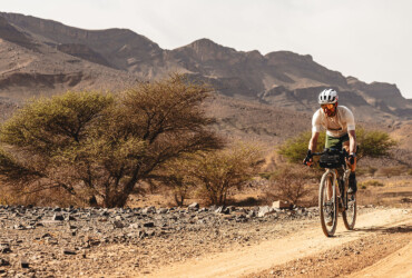 Un cycliste sur les terres sableuses et désertiques du Maroc