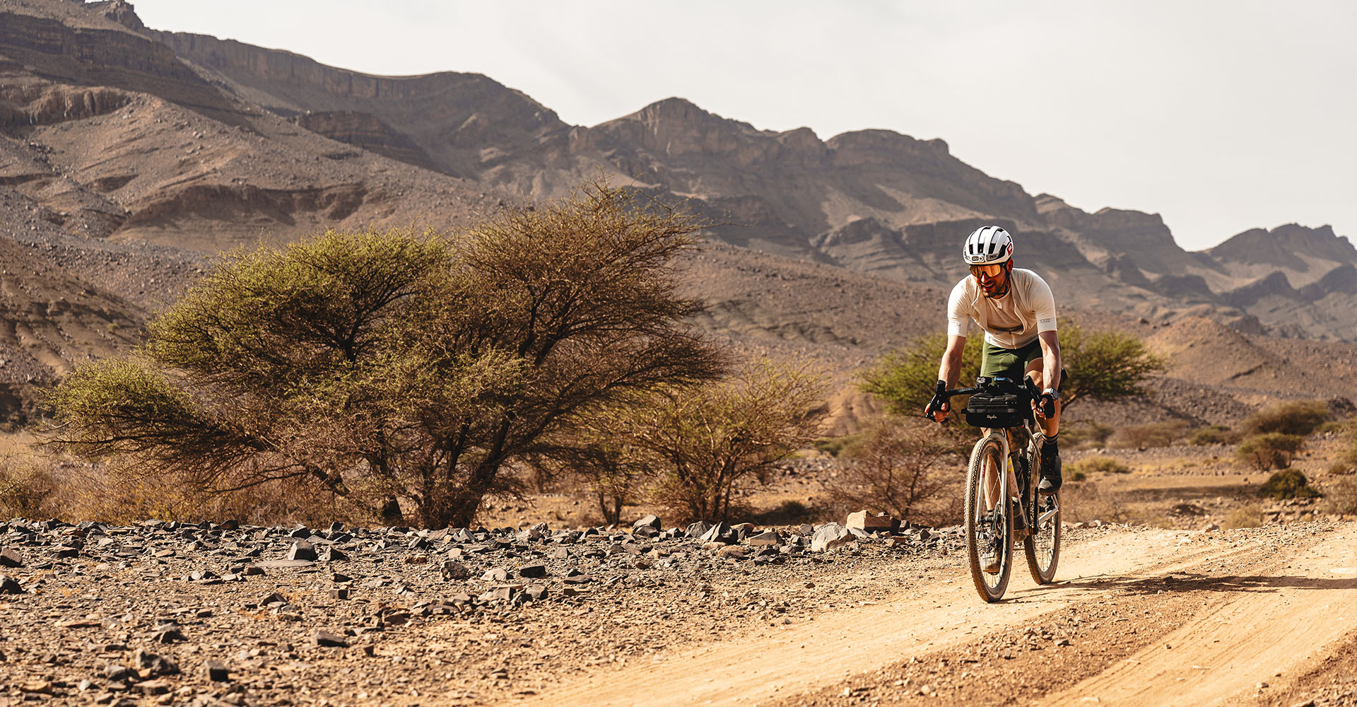 Un cycliste sur les terres sableuses et désertiques du Maroc