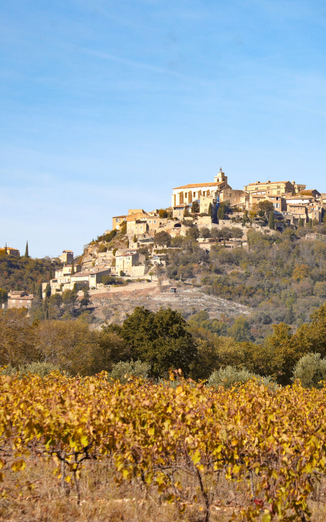 La ville de Gorde surplombant des vignobles orangés d'automne