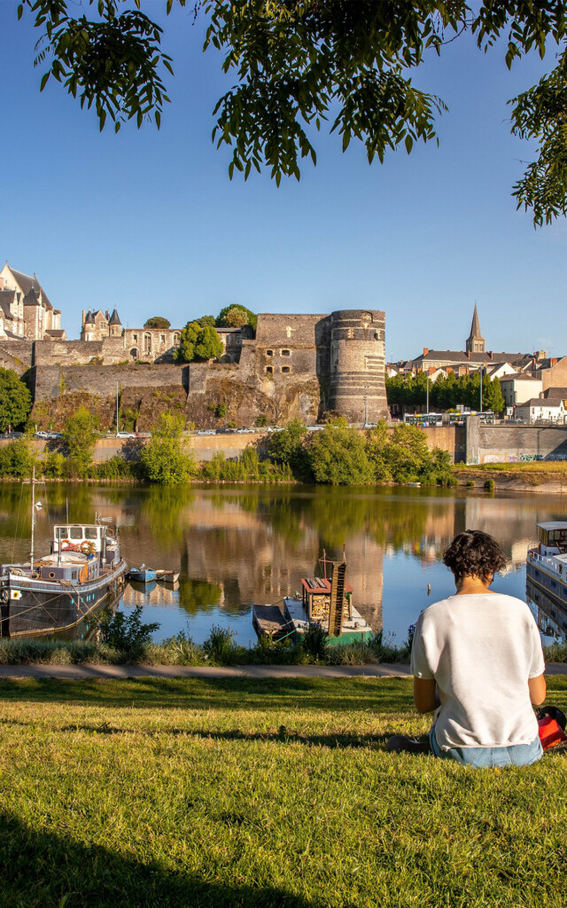 Un homme se repose devant les rives de la ville d'Angers