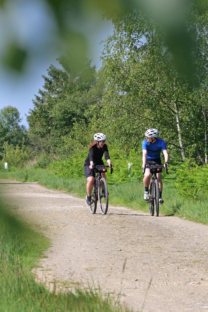 Deux cyclistes roulent l'un a cote de l'autre et rient