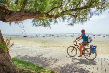 Woman riding her bike along the beach