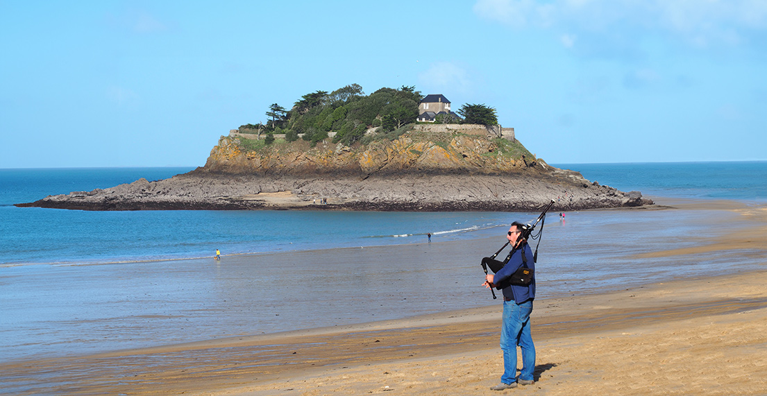 La anse du Guesclin avec un homme jouant du biniou