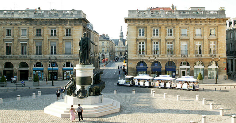 Un couple se balade sur la Place Royale du centre de Reims