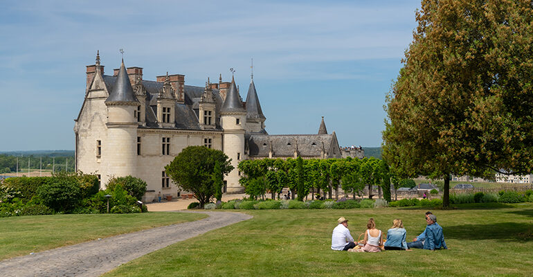 Un groupe d'amis assis dans l'herbe devant le château d'Amboise