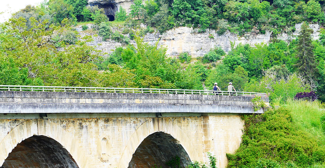 Un couple de cyclistes traverse un pont