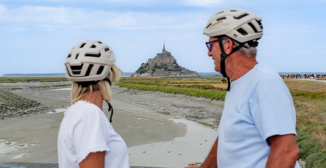 Un couple de cyclist regarde le mont saint michel