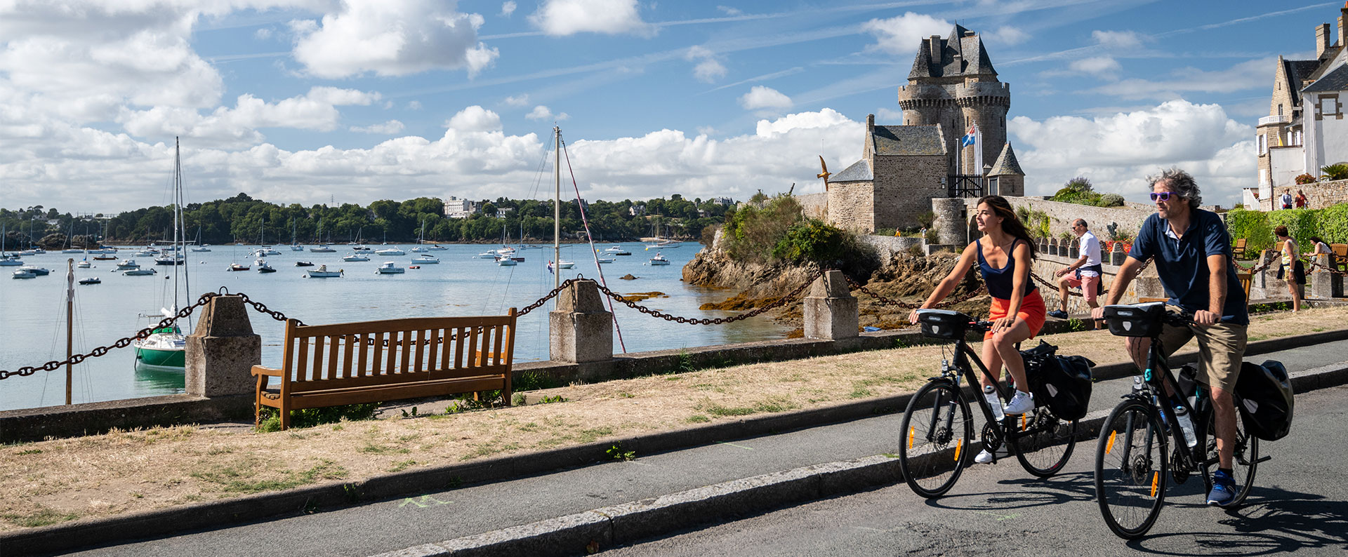Un couple de cyclistes roule le long de la mer