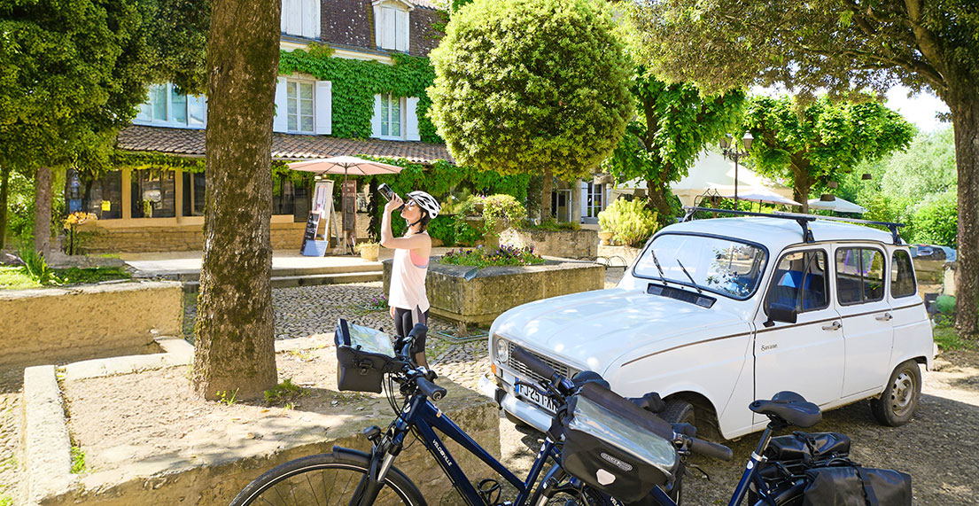 Une cycliste prend une pause dans un petit village typique