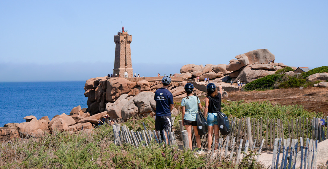 Un groupe d amis cyclistes regarde le phare rose de Ploumanach