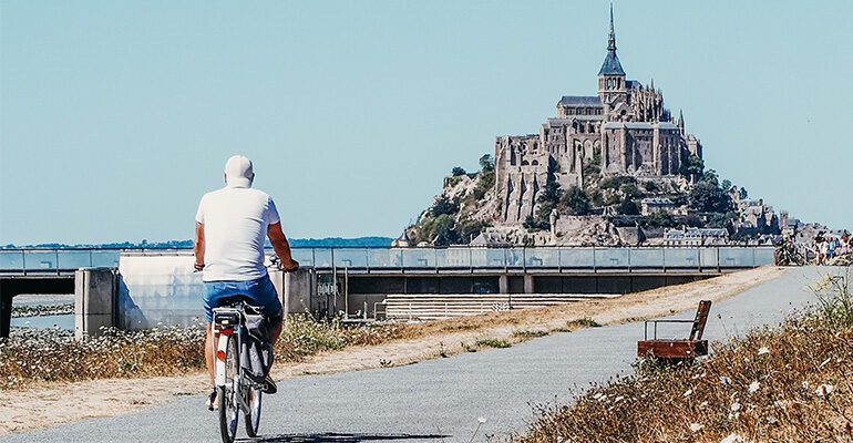 Un cycliste se dirige vers le Mont-Saint-Michel via la piste cyclable