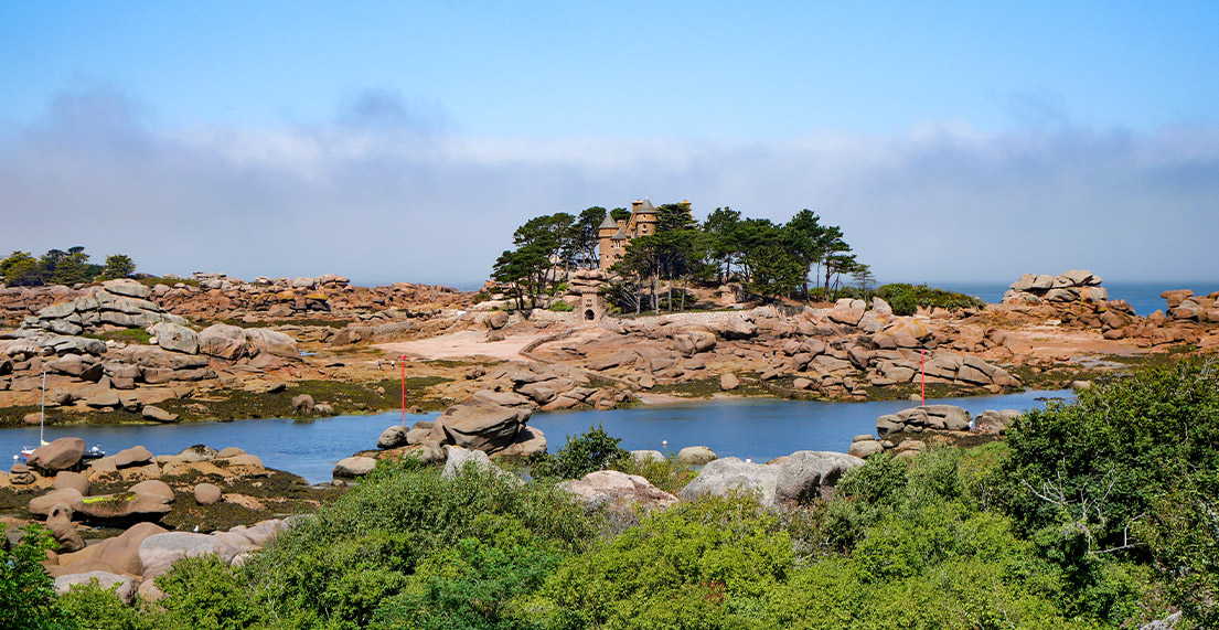 Une ile avec un chateau rose entoure d eau de mer