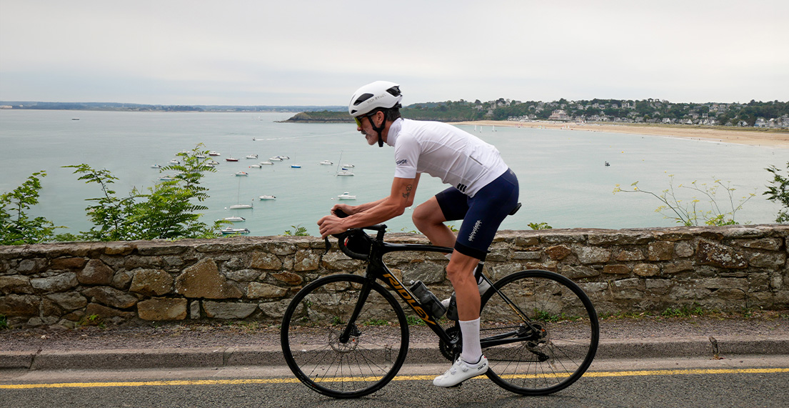 Un cycliste roule le long d'une route borde par la mer
