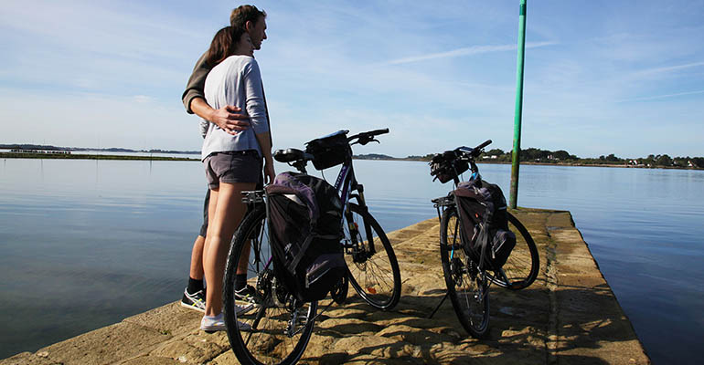 Cyclistes avec leurs vélos contemplant le Golfe du Morbihan