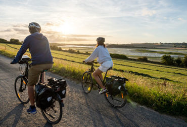 couple à vélo au soleil couchant sur les bords de la Rance