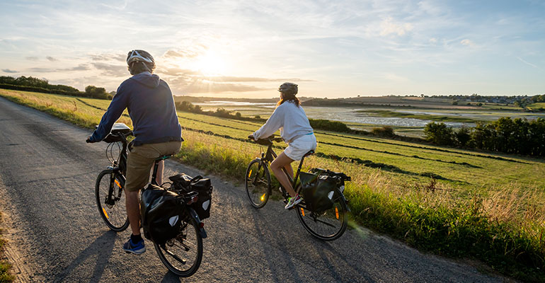 couple à vélo au soleil couchant sur les bords de la Rance