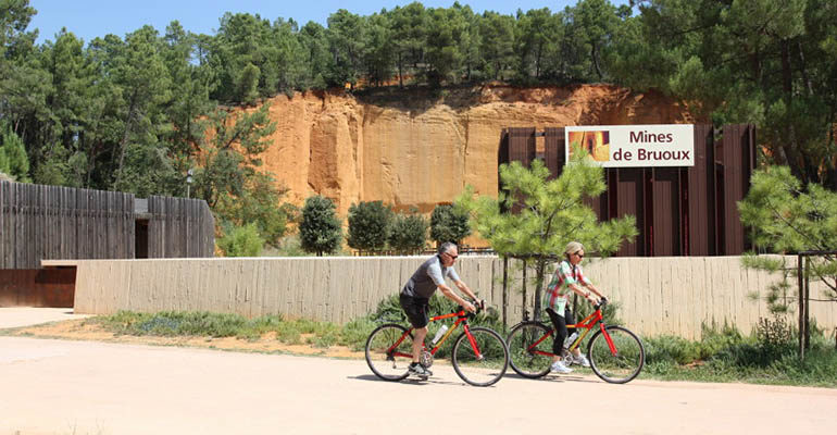 Couple à vélo passe devant les mines de Bruoux Le petit tour du Luberon