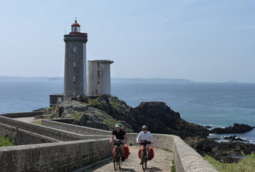 Couple de cyclistes quittant un phare en Bretagne