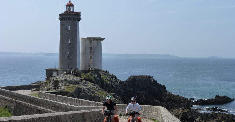 Couple de cyclistes quittant un phare en Bretagne