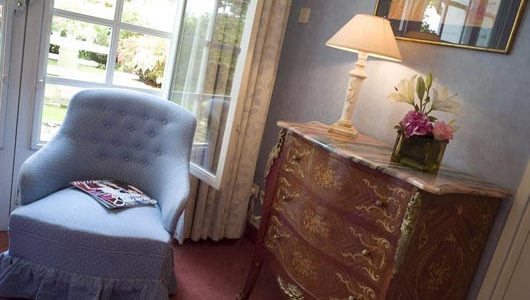 Fauteuil et commode dans une chambre Hôtel le Chateau De Beaulieu à Joué-lès-Tours