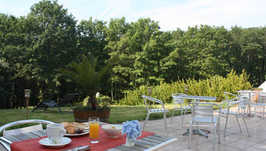 Petit-déjeuner en terrase donnant sur jardin arboré Hôtel Latitude Ouest à Locronan