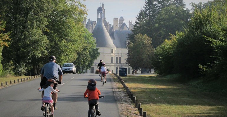 Famille à vélo arrivant au château de Chambord