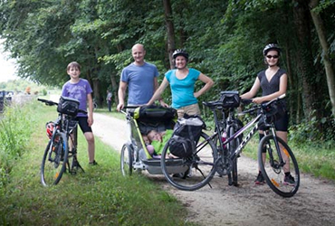 Photo d'une famille avec ses vélos pause en forêt pendant vacances à vélo