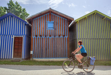 Un cycliste roule devant les cabines colorées de la Vélodyssée