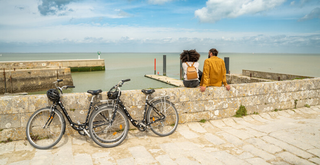 Une couple de cycliste fait une pause devant un port