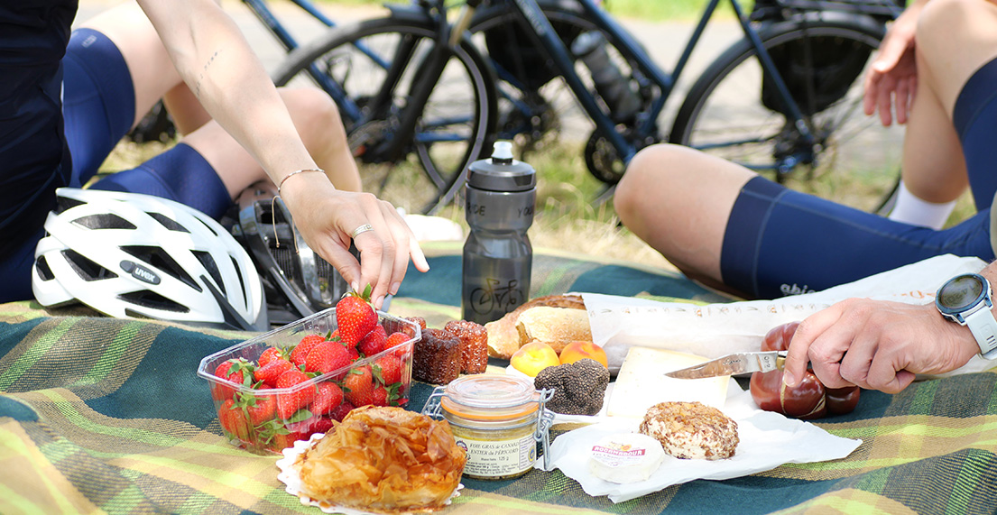 Un couple de cyclistes pique-nique avec des produits régionaux