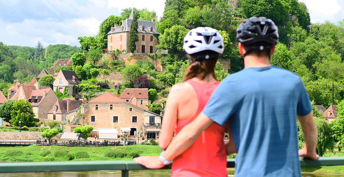 Un couple de cycliste regarde un chateau