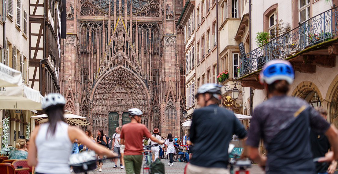 Un groupe de cycliste se balade devant la cathédrale de Strasbourg