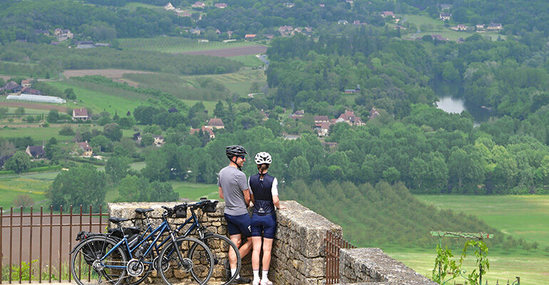 Deux cyclistes admirant un panorama sur la campagne