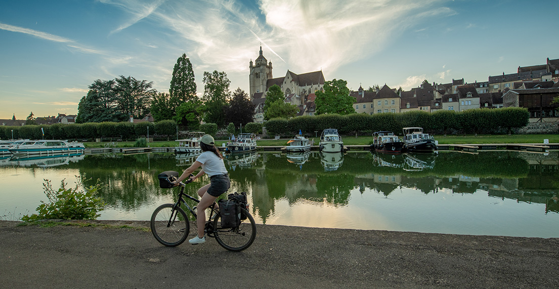 Une cycliste roule le long du Canal de Bourgogne