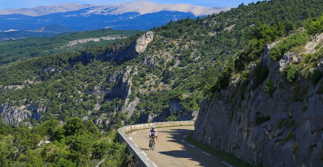Un cycliste roule sur une route de montagne
