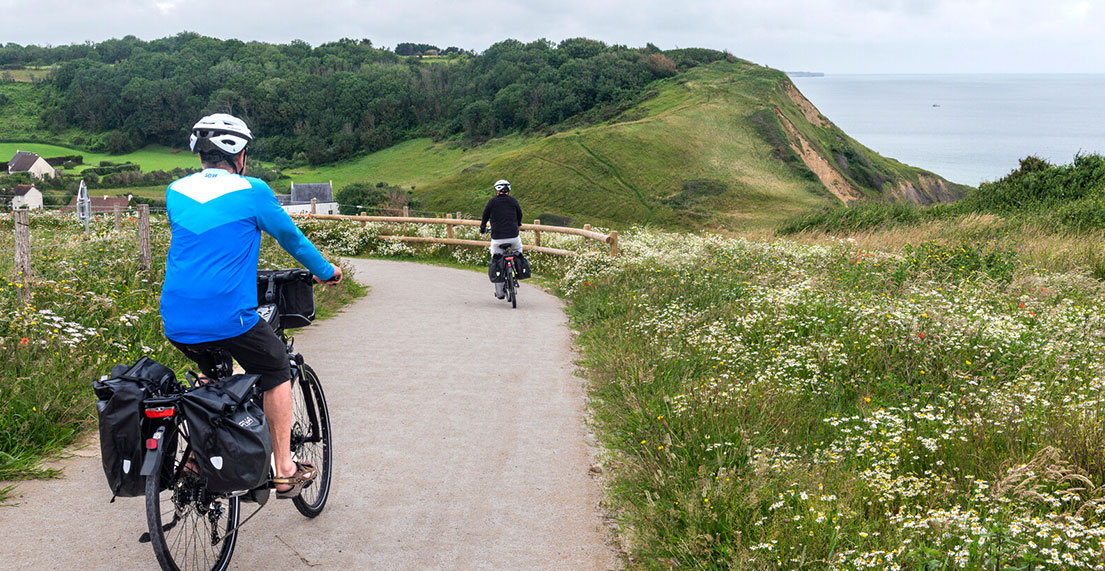 Un couple de cycliste traverse le bocage normand fleuri