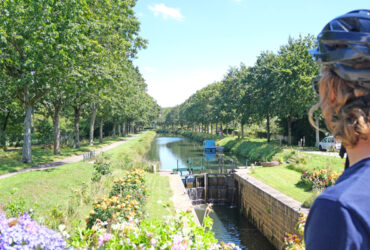 Un cycliste regarde en direction des écluses du Canal de Nantes à Brest