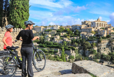 Un couple de cycliste regarde la ville perche de Gordes