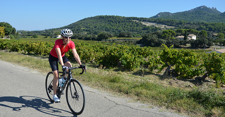 femme cycliste au milieu des vignes en Provence