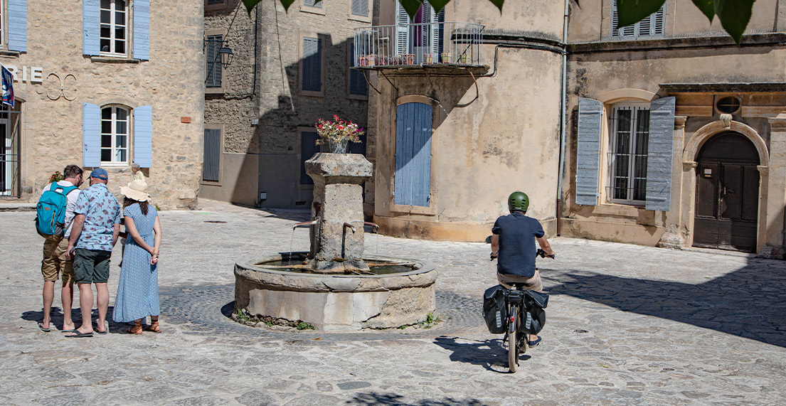 Un cycliste roule sur les rues pavees d'une petite ville
