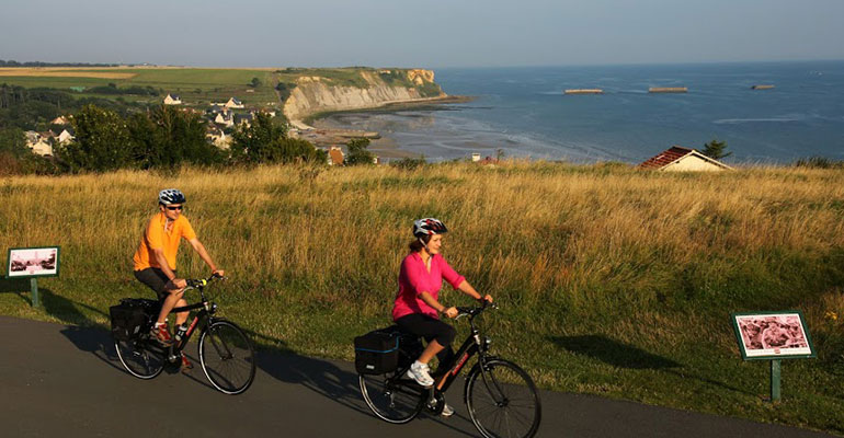 Cyclistes à Arromanches le long de la côte